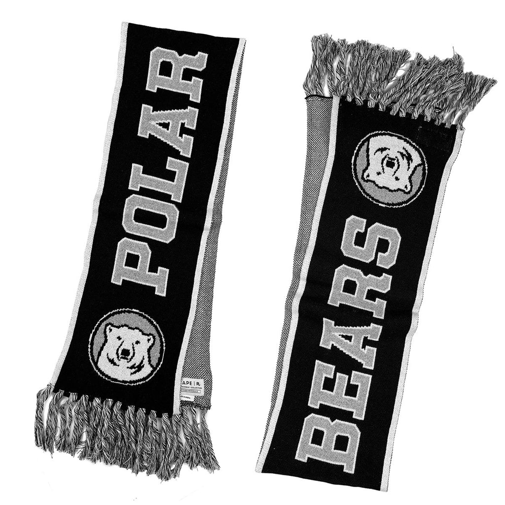 Both sides of front of scarf: it is black with a white border and black, white, and grey tassels on the ends. Knit in on each end are polar bear medallions. The words POLAR BEARS are knit in grey with a white stroke.