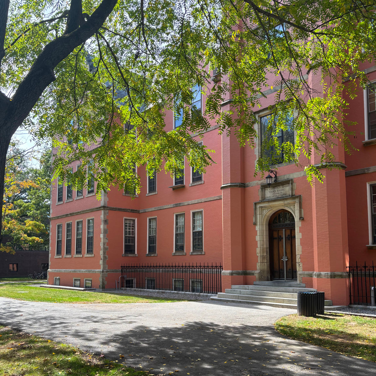 Photo of Searles Hall as seen through the branches of a walnut tree.