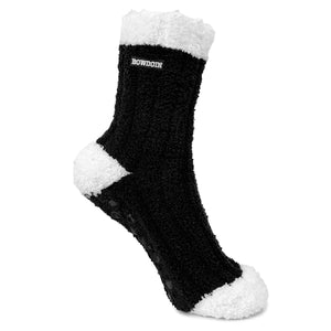 Fuzzy black sock with contrast white toe, heel, and cuff. Small black rectangular embroidered patch with white BOWDOIN in athletic logotype at top of sock just below cuff.