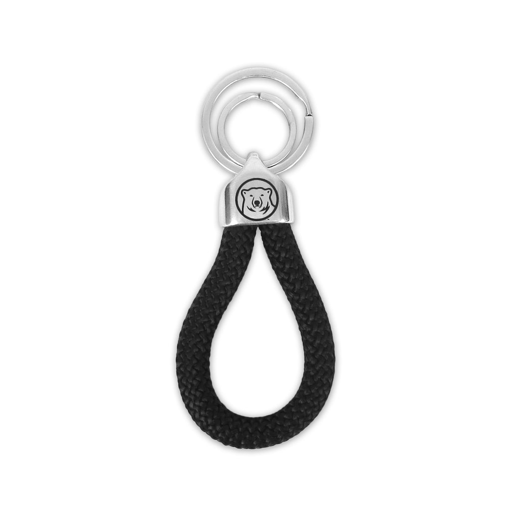 Chrome key tag with black rope loop, polar bear medallion imprint on cap, and double concentric key rings.