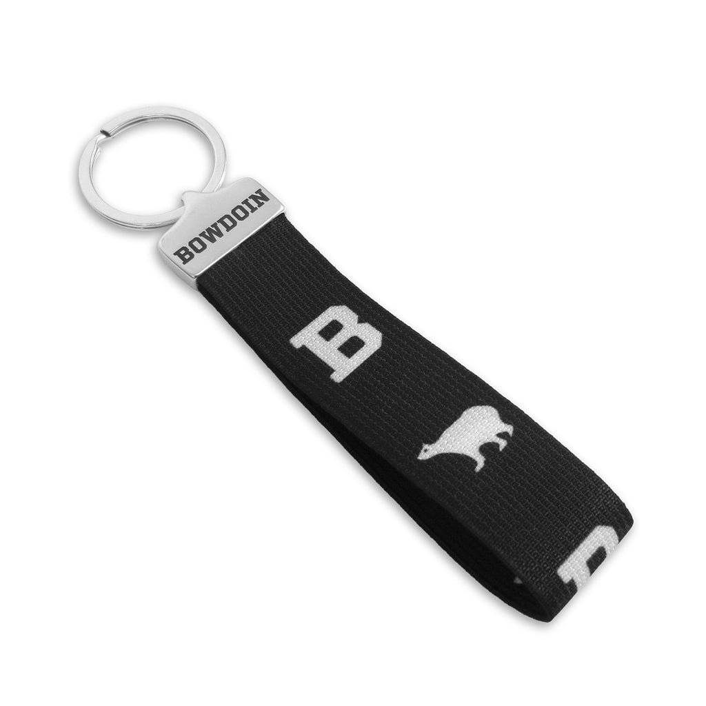 Wristlet keyring with silver cap engraved with BOWDOIN in athletic type, black loop with white repeating design of B and polar bear.