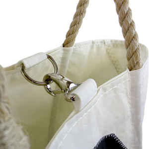 Closeup detail of spring clasp closure on handbag.