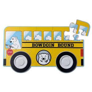 15-piece children's puzzle shaped like a yellow school bus. The driver and passengers are polar bears, and the side of the bus has the text BOWDOIN BOUND and a polar bear mascot medallion.