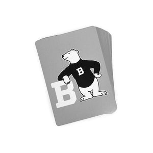 Deck of playing cards with grey backs imprinted with a cartoon polar bear leaning on a white letter B. The bear is wearing a black sweater decorated with the letter B in white.