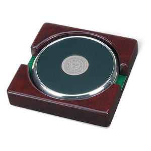 Burgundy piano wood stand holding two round black leather coasters with silver rim and silver engraved Bowdoin sun seal in center.