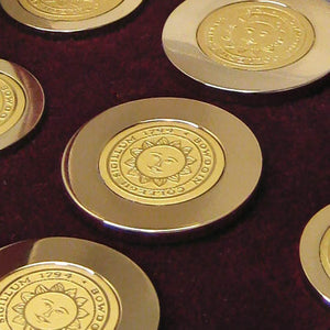 Closeup of brass blazer buttons showing engraving detail.