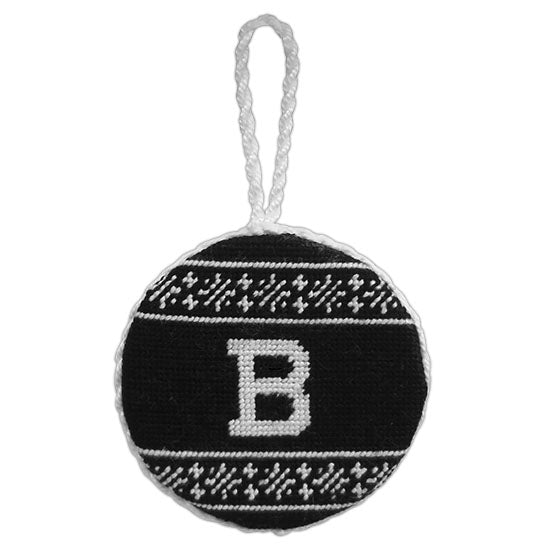 Round black needlepoint ornament with Fair Isle design on top and bottom in white, and white B between. White trim and hanger.