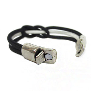 Back of Bracelet made of black and white cord, tied in a single carrick knot, showing open metal clasp.