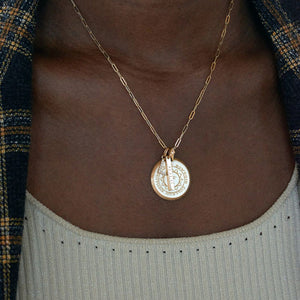 Black woman wearing a single chain with a grad date bar and a Bowdoin seal Florentine.