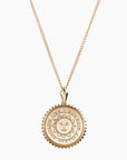 Small round gold pendant necklace with Bowdoin sun seal engraving, surrounded by sunburst edging.
