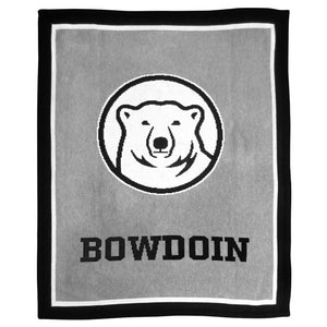 Knit blanket in grey with thin white inner border and thick black outer border. In the center of the blanket is a large knit-in Bowdoin mascot medallion over the word BOWDOIN.