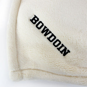 Closeup detail of black BOWDOIN embroidery in corner of cream white plush throw.