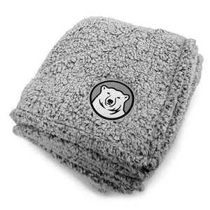 Frosty grey sherpa blanket with embroidered mascot medallion in corner.