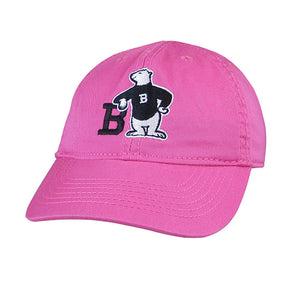 Pink twill hat with Spirit Bear embroidery: A polar bear wearing a black sweater with a white B on it, leaning with one elbow on the letter B and its other hand on its hip.