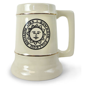 Ivory ceramic stein mug with two gold stripes and black BOWDOIN sun seal imprint between gold stripes.