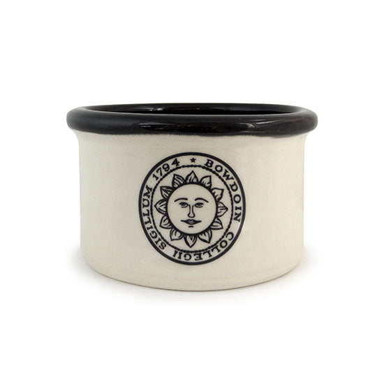 Natural tone ramekin with straight sides and black interior. Black sun seal imprint on front.