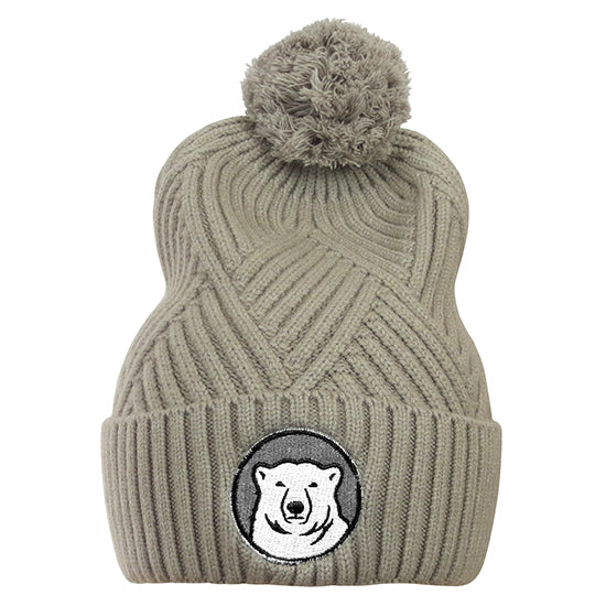 Tan cuffed pom beanie with polar bear medallion patch on cuff.