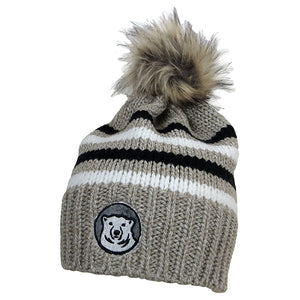 Tan beanie with embroidered mascot medallion patch and black and white stripes. Tan/brown faux fur pom.