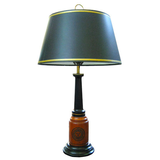 Wooden lamp with black base bottom and upper, maple-stained middle base engraved with Bowdoin College seal. Black shade with gold trim.