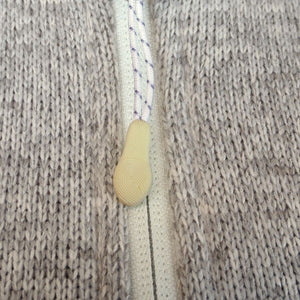 Closeup of rubberized zipper pull on oatmeal fleece.