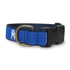Blue dog collar with blue ribbon with repeating white Bowdoin mascot decoration. Black plastic clip closure and brass D ring.