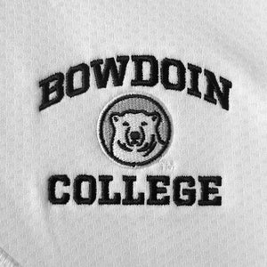 Closeup detail of embroidery on white pullover. Black arched BOWDOIN over mascot medallion over black COLLEGE. 