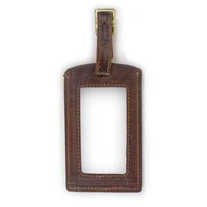 Reverse view of brown luggage tag showing window for contact information.