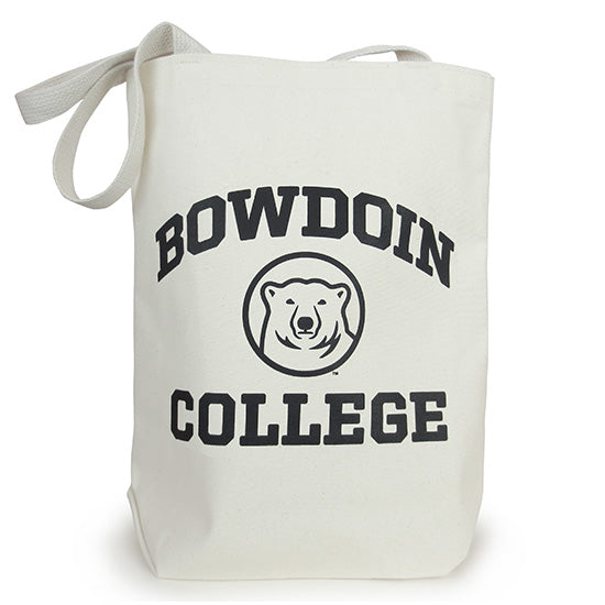 A natural-colored canvas tote bag with black BOWDOIN COLLEGE and polar bear medallion imprint. BOWDOIN is arched over the bear head medallion, and COLLEGE is in a straight line underneath the medallion.