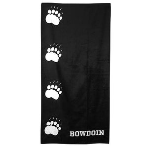Black beach towel with line of 4 white paw prints vertically on left side. BOWDOIN in white on lower right corner.