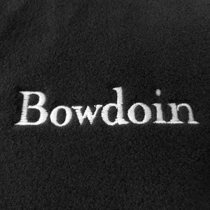 Closeup of white Bowdoin embroidered on black fleece.
