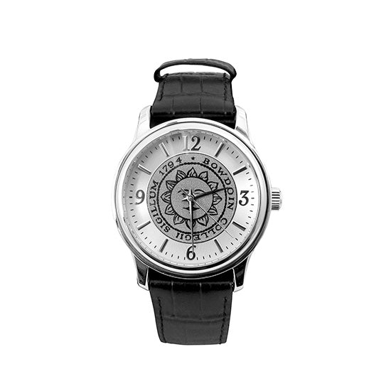 Silver tone wristwatch with black strap. Bowdoin sun seal on face, which has silver hour markers with arabic numerals at 12, 3, 6, and 9.